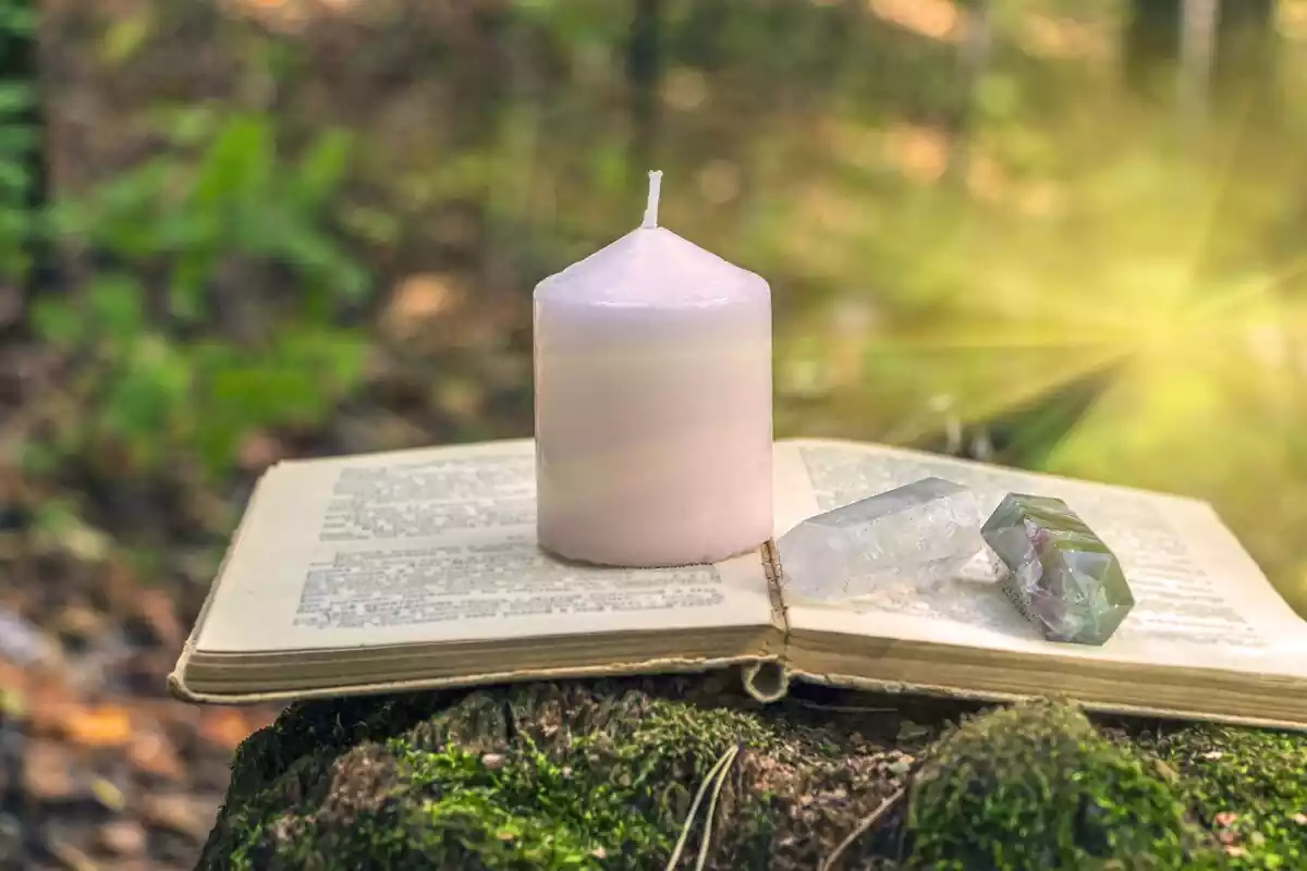 A book a candle and a stone in nature