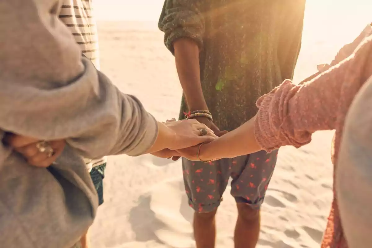 Friends holding hands at the beach