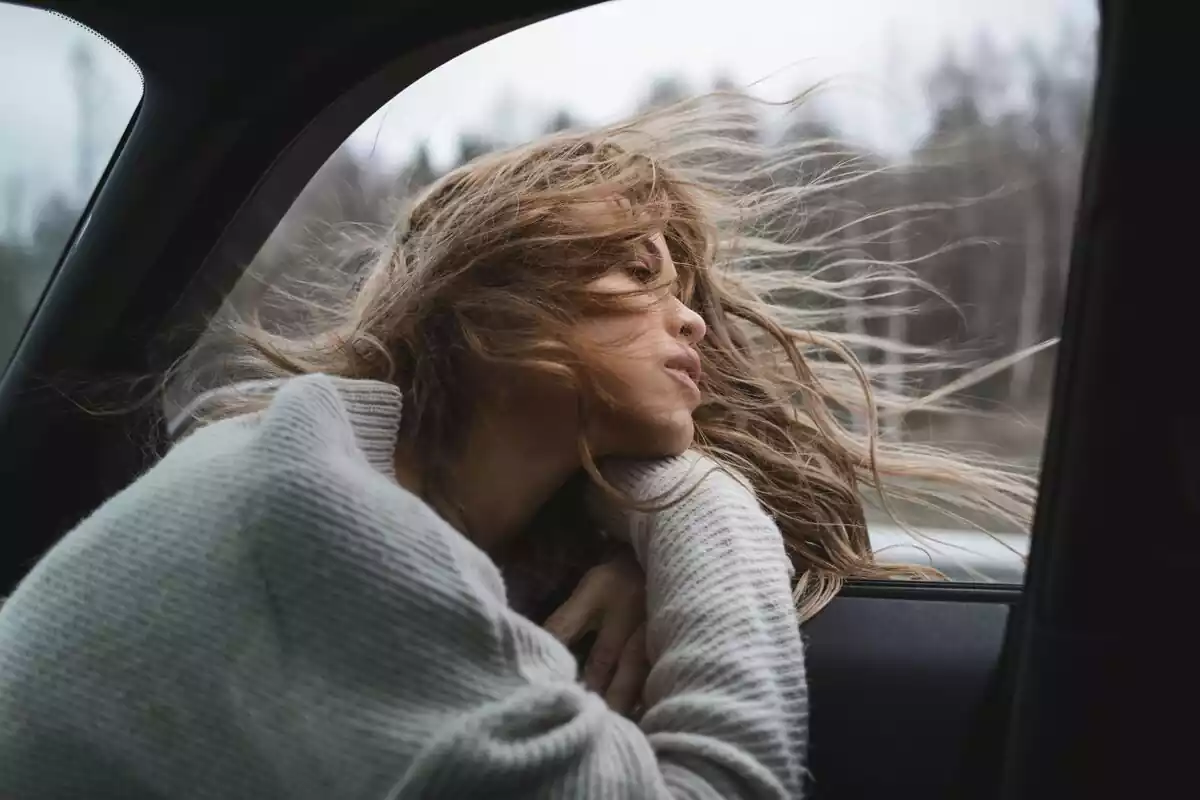 Girl in a car with wind blowing her hair