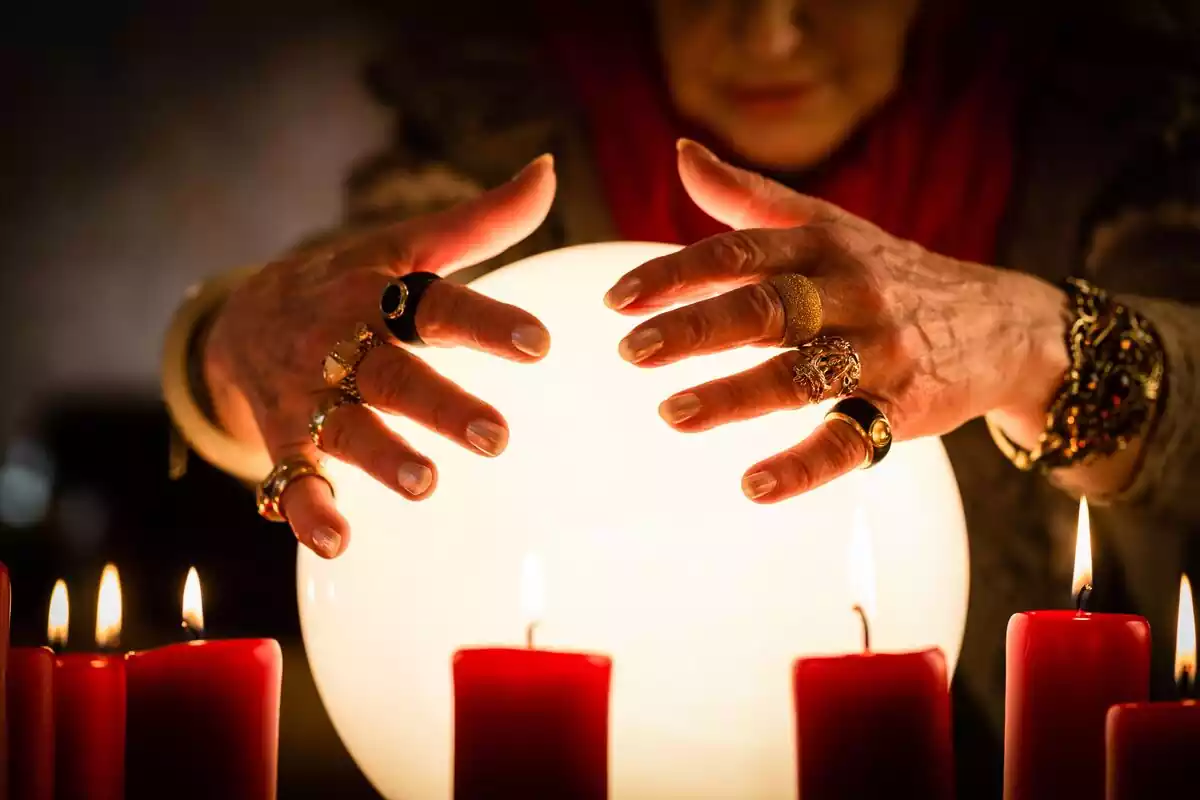 Hands of a fortune teller on a shining ball